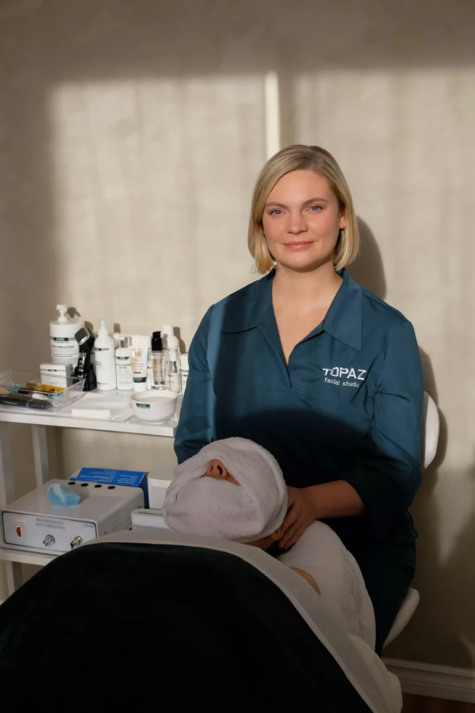 Topaz esthetician seated with a client prepared for a facial treatment.