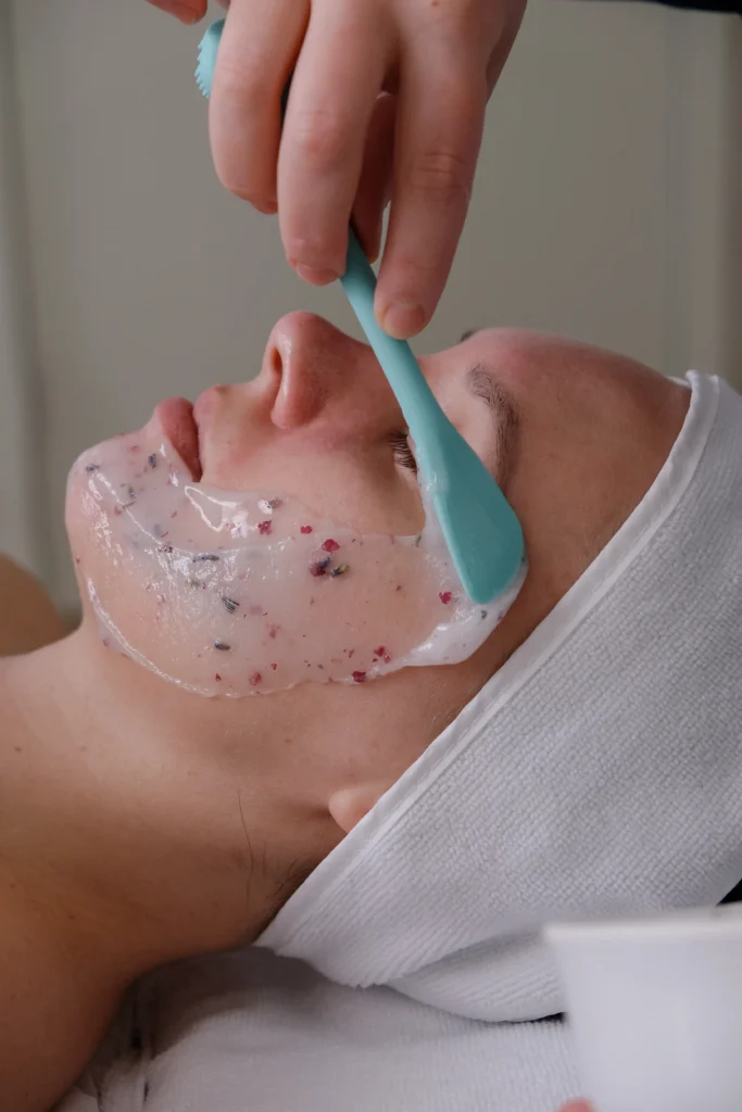 Close-up of a professional facial mask being applied.