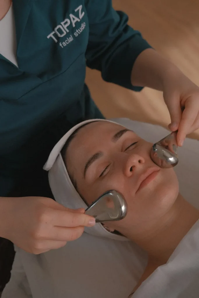 Topaz practitioner using handheld facial tools on a client.